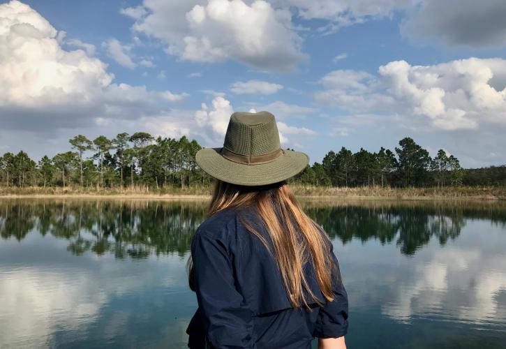 FPS employee at catfish creek staring at a pond and tree line