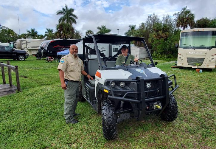 Two men UTV green grass