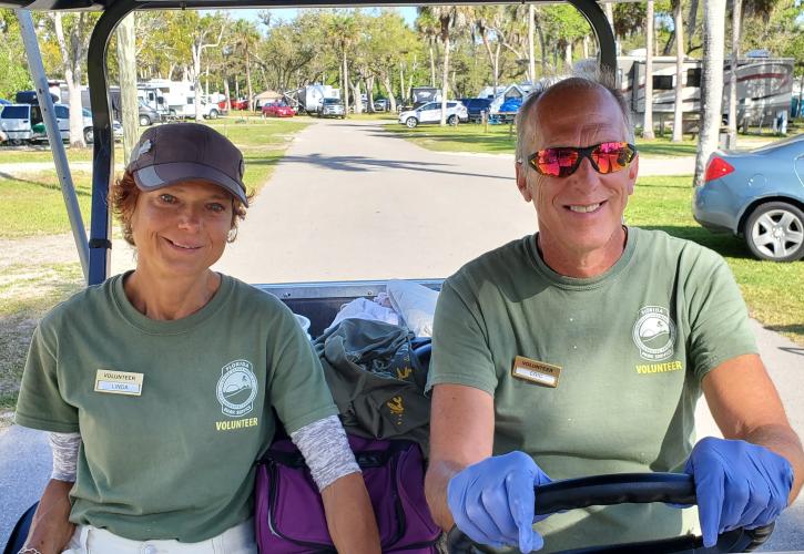 woman and man driving a golf cart