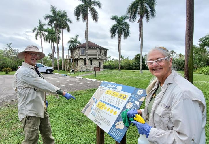 Man and woman pointing to bear aware information panel