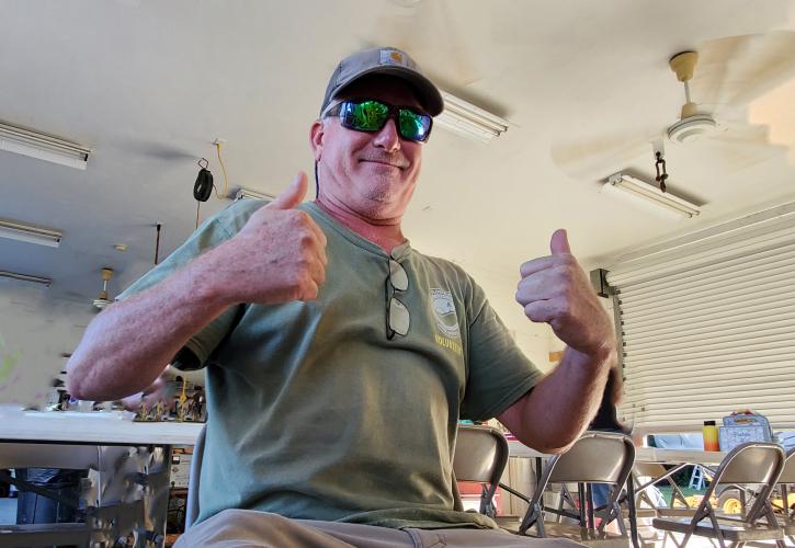 man wearing green shirt sunglasses and a hat