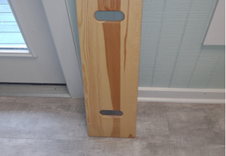 A transfer board leaning against the wall.