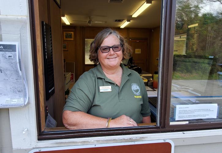 woman in green shirt volunteering in ranger station office