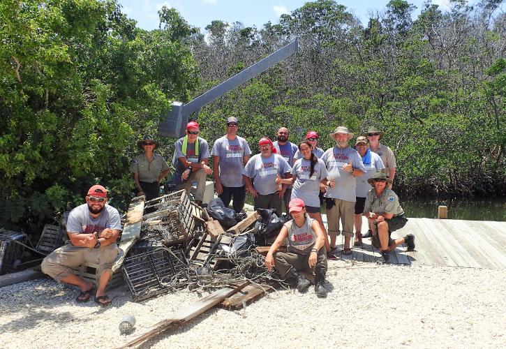 Group poses on dock with the marine debris removed from the island