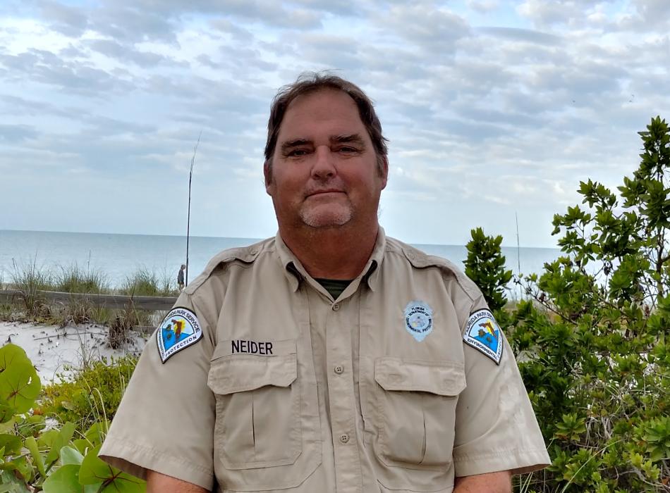 Park Ranger Ken Neider standing in front of beach
