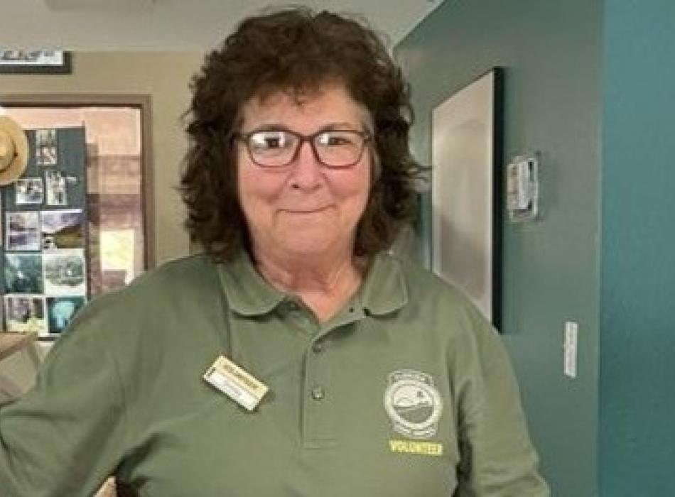 Shirley Johnson standing in a room smiling.