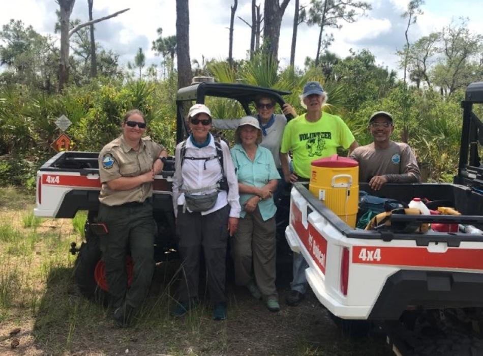 people on in the woods with UTVs