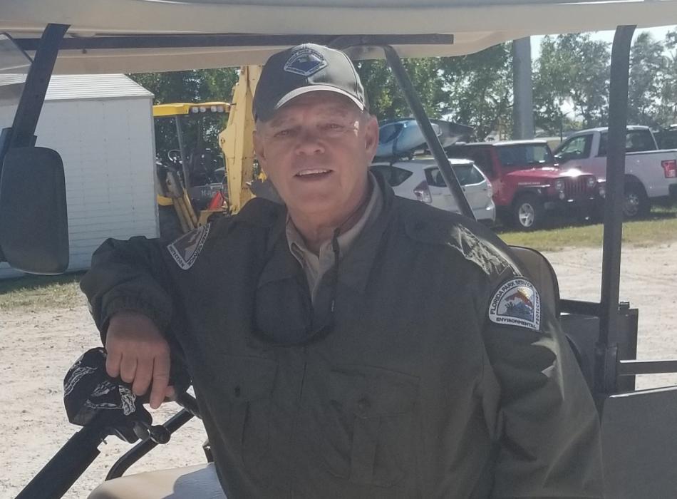 Bill Smith, Leaning on a cart, smiling at the camera, and wearing his ranger uniform.