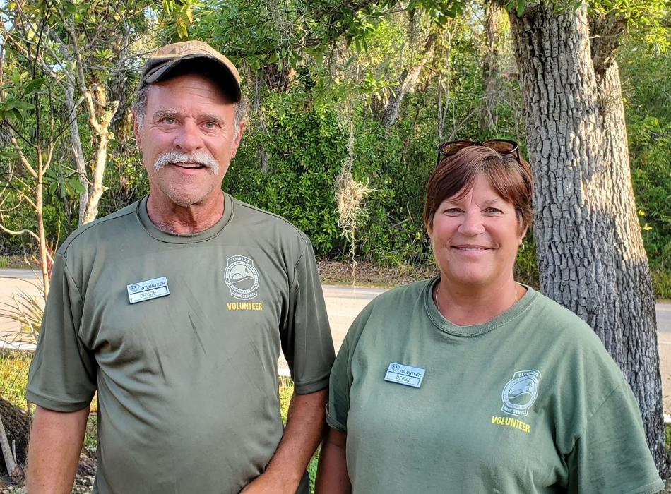 Two people wearing green shirts