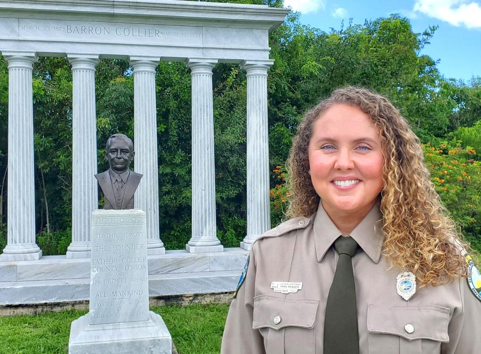 Park Ranger Lauren Sheppard standing at the Barron Gift Collier Memorial.