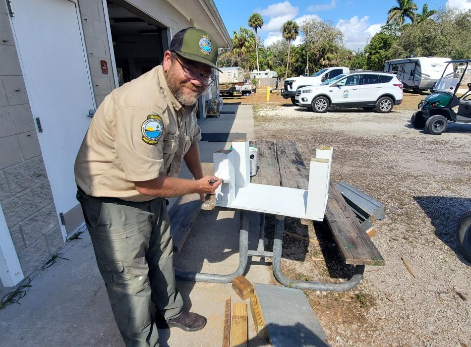 Park Ranger David painting a table he built for the ranger station.