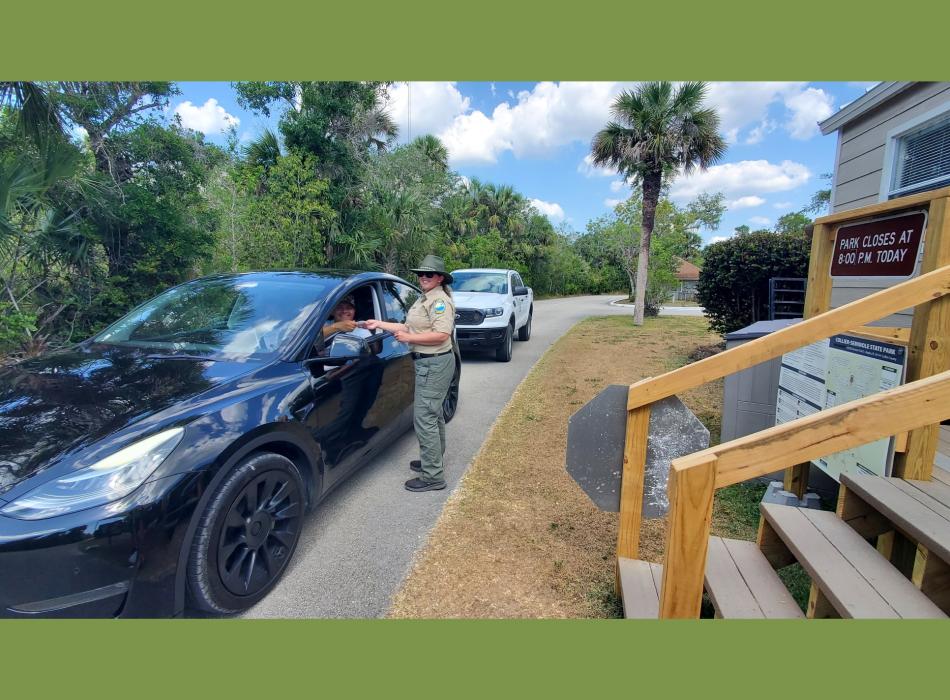 Park Ranger Lauren Sheppard is assisting a park visitor at the Ranger Station.