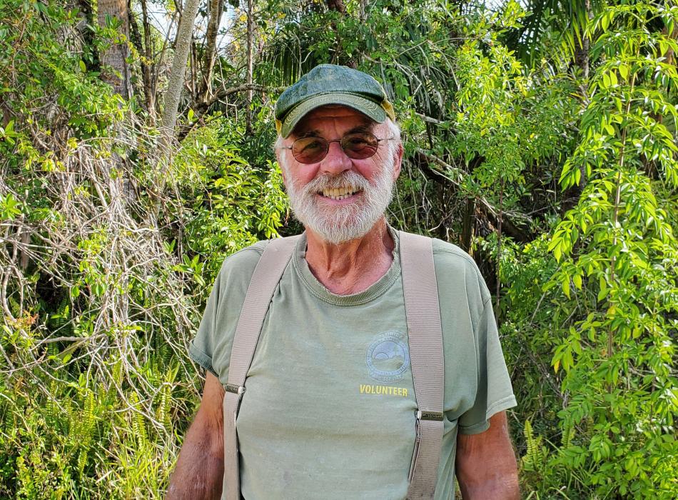 Person standing green vegetation hat