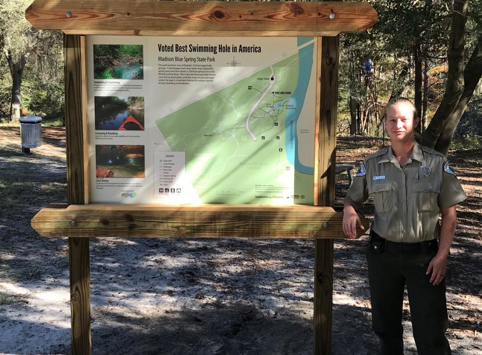 April, standing outside by a map of the park.