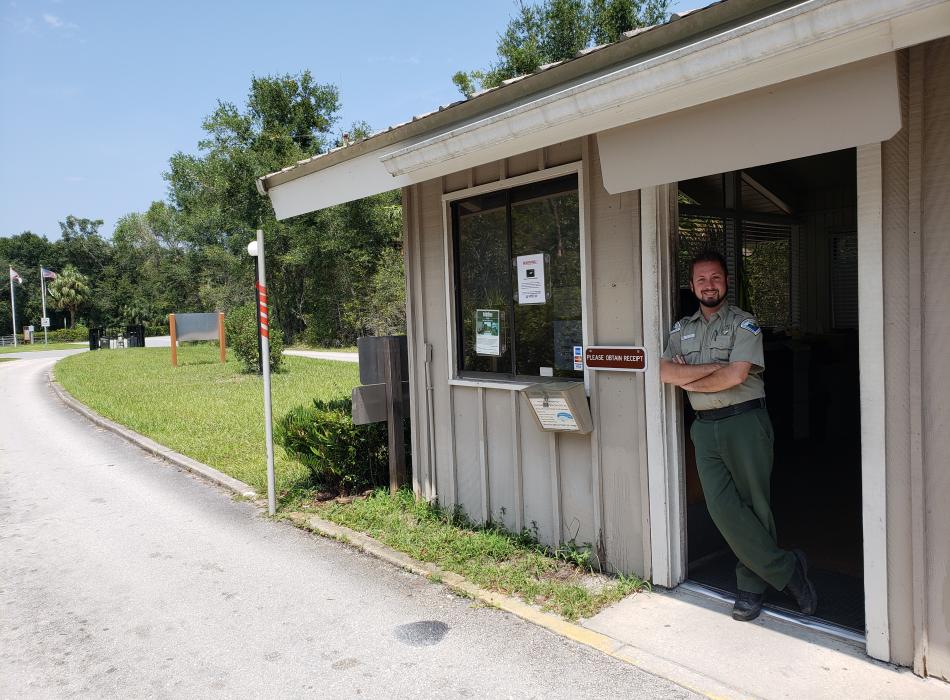 Jim, standing in the doorway of the ranger station, smiling at the camera.