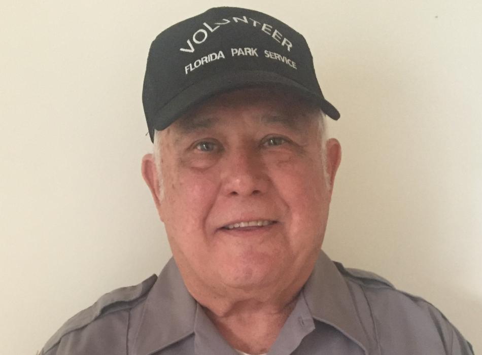 Sammy Alba, smiling at the camera, wearing his volunteer uniform.