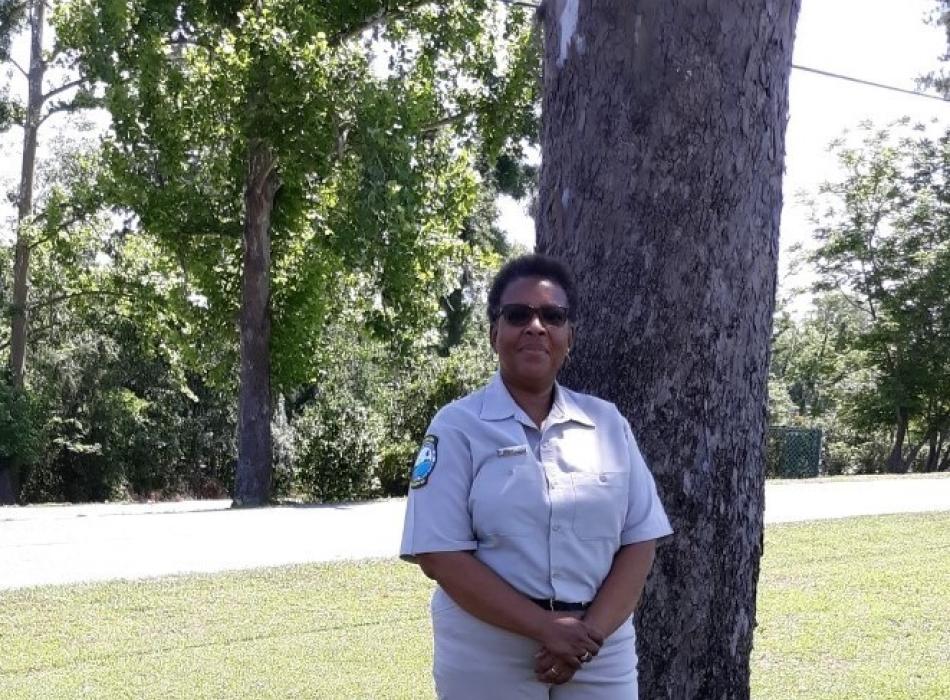OPS Park Ranger Shearyl Lovett standing beside a pine tree.