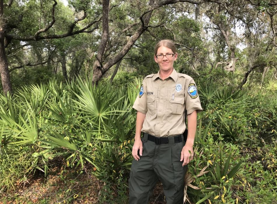 Kate Smithson, wearing her ranger uniform, smiling at the camera.