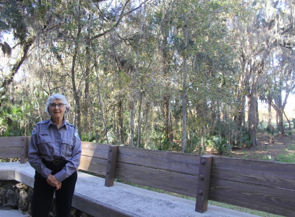 Image of volunteer Fairlie Bagley on the back porch of paynes prairie visitor center.