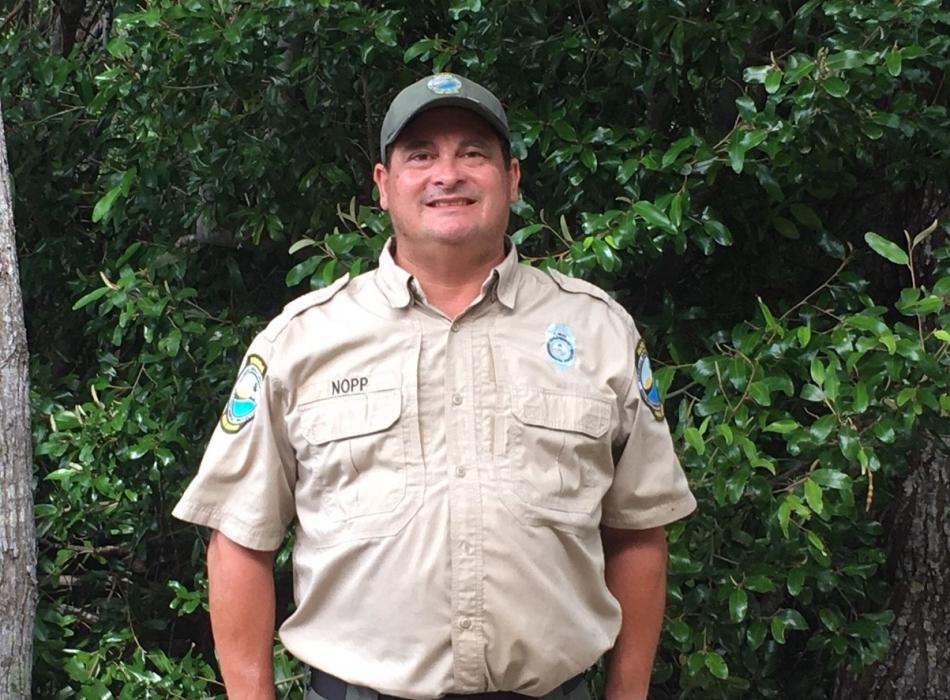 Park Ranger Garin Nopp standing in front of greenery