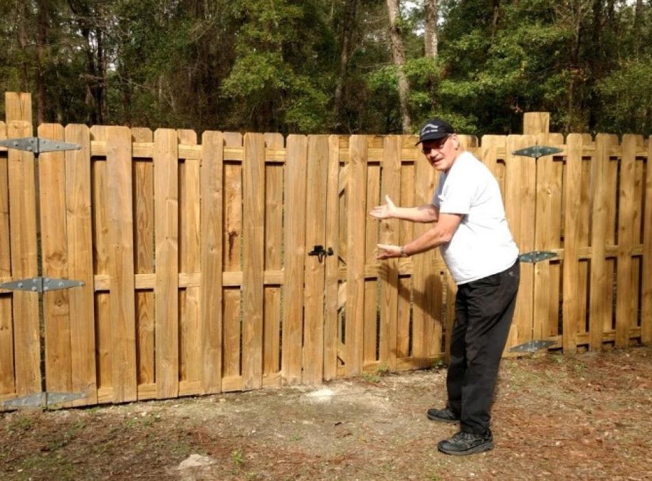 Clenn Copp, park volunteer, is seen standing next to a wooden fence at Suwanee River State Park.