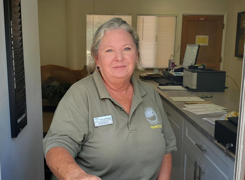 Person with blonde hair wearing a green shirt