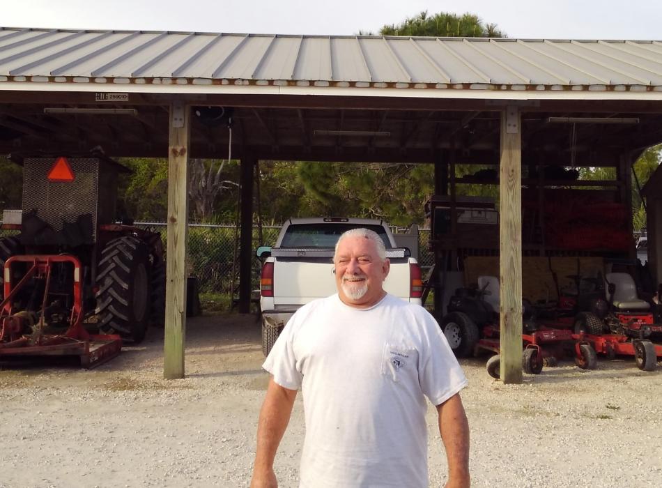 Ken Mercer standing in front of the work shop.